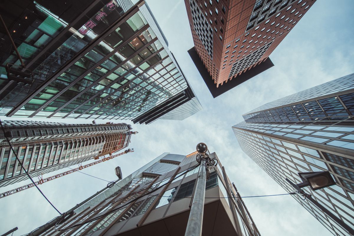 Looking up at modern skyscrapers creating a striking urban perspective against the sky