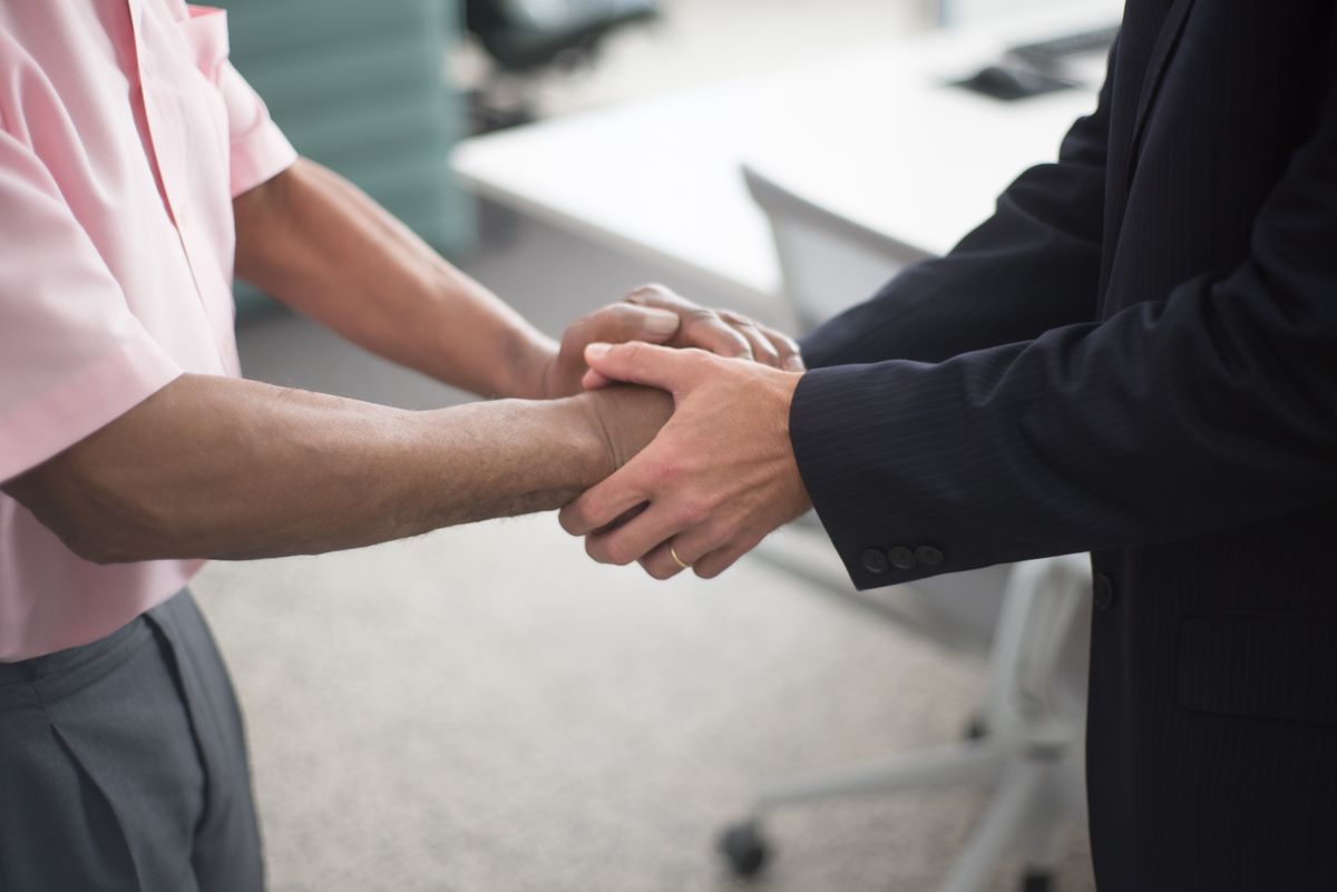 Handshake between two business professionals symbolising a corporate merger
